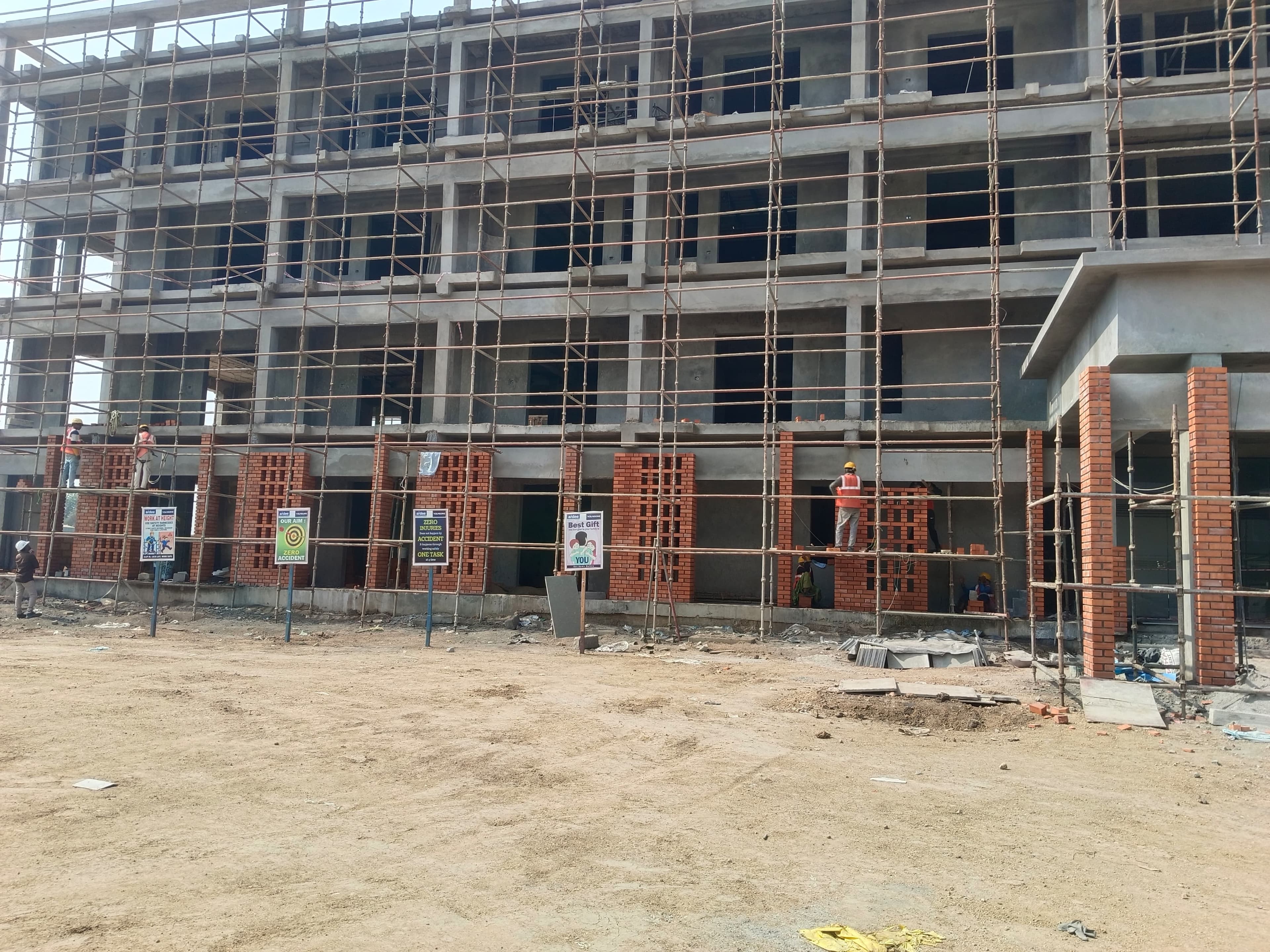Multi-storey commercial complex featuring exposed wire-cut red brick jali facade under construction in Warangal
